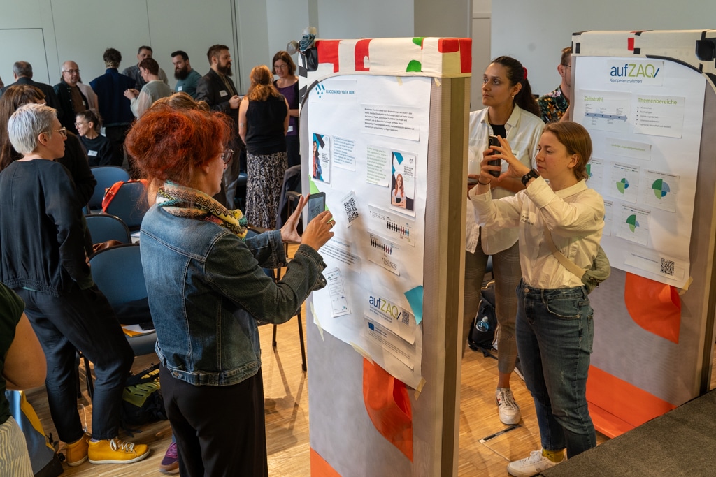 Menschen fotografieren Infostände beim aufZAQ Impuls.Brunch. Networking und Austausch im Fokus.