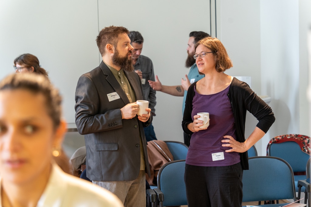 Zwei Personen unterhalten sich mit Kaffeetassen beim aufZAQ Impuls.Brunch. Networking und Austausch.