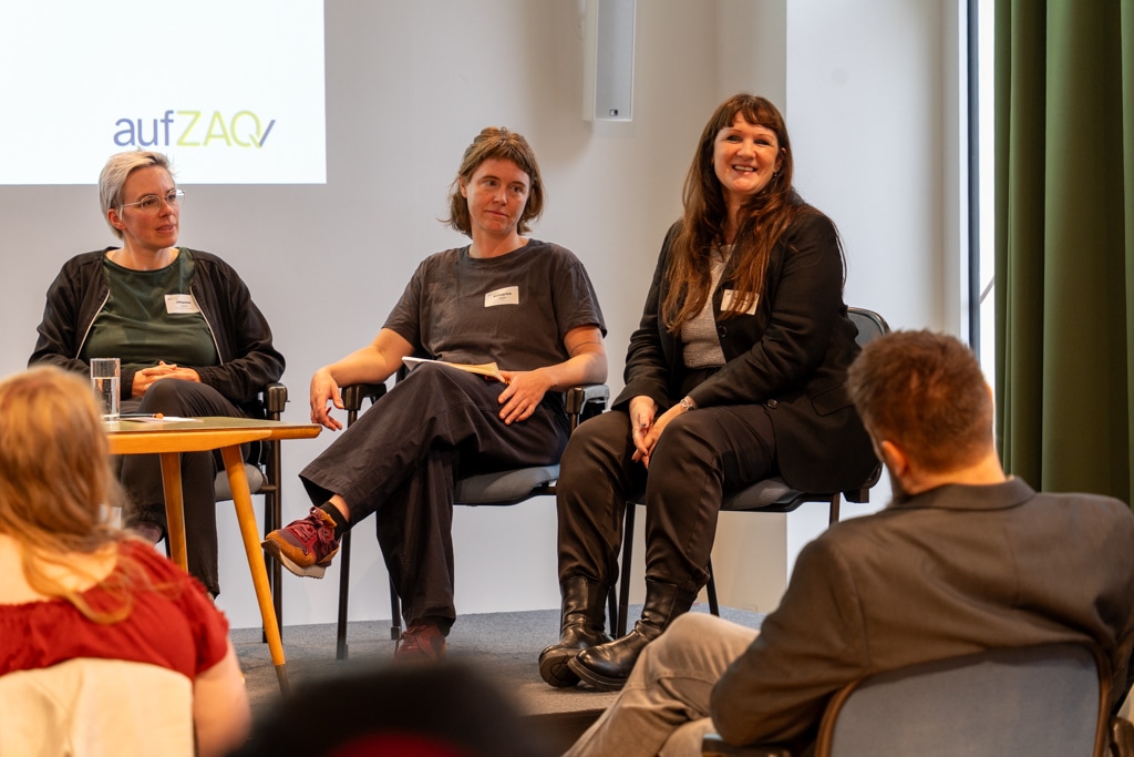 Drei Frauen sitzen auf Stühlen während eines aufZAQ Impuls.Brunchs und sprechen mit einem Publikum.