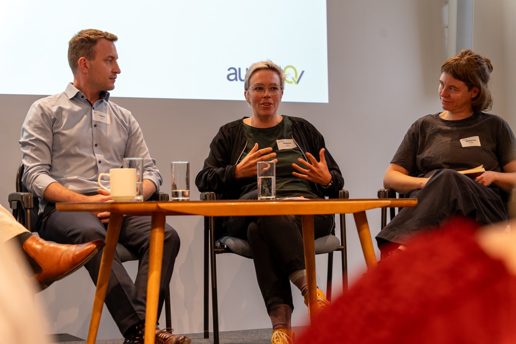 Drei Personen sitzen auf einer Bühne während des aufZAQ Impuls.Brunch.